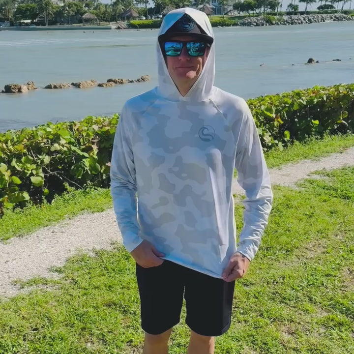 Video of an angler on the waterfront turning to show the front, back and thumbhole cuffs of the HOOKSTER Shadow Camo UPF 50+ UV hoodie in light gray and white camo